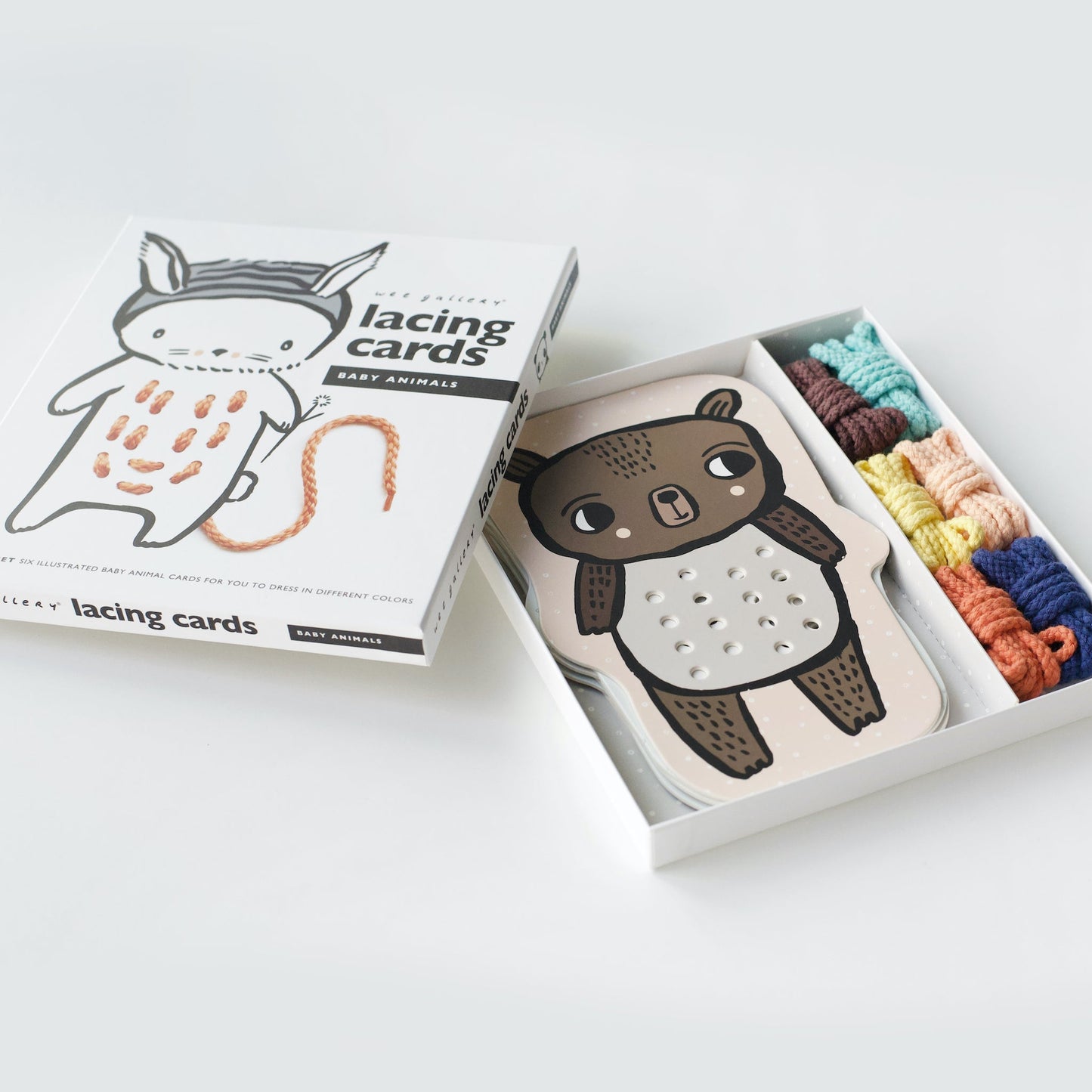 Lacing cards with animal illustrations and colorful strings on a white background
