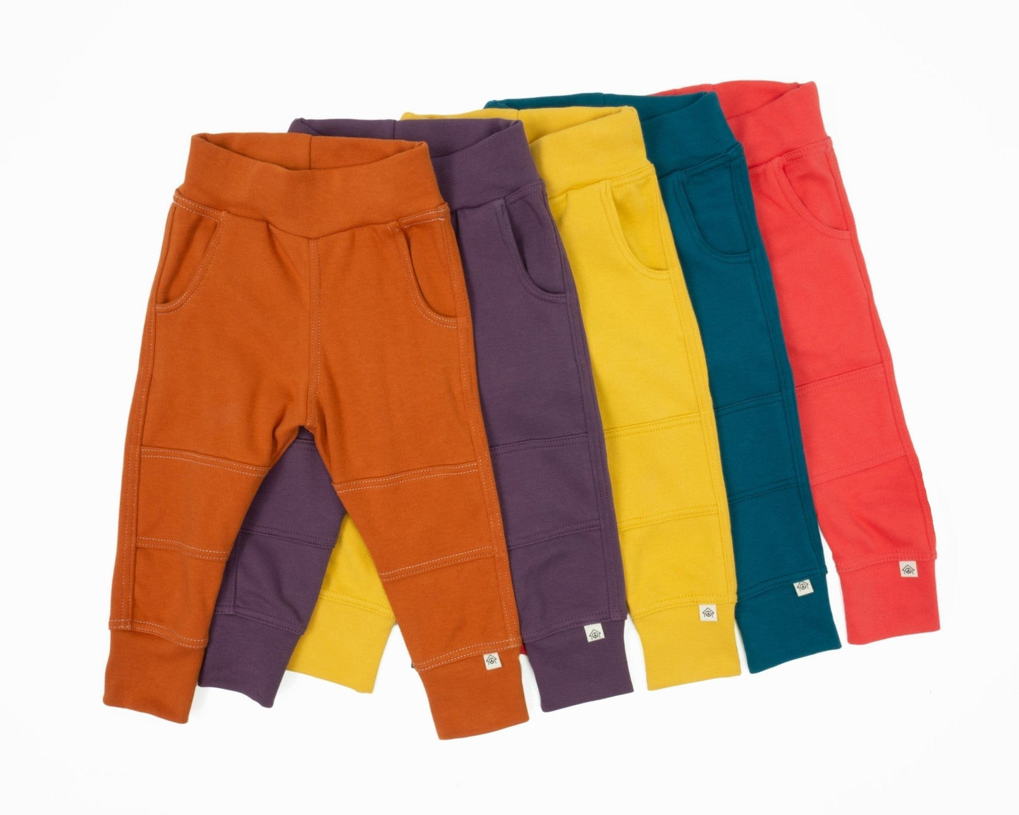 Five pairs of colorful sweatpants in orange, purple, yellow, blue, and red on a white background.