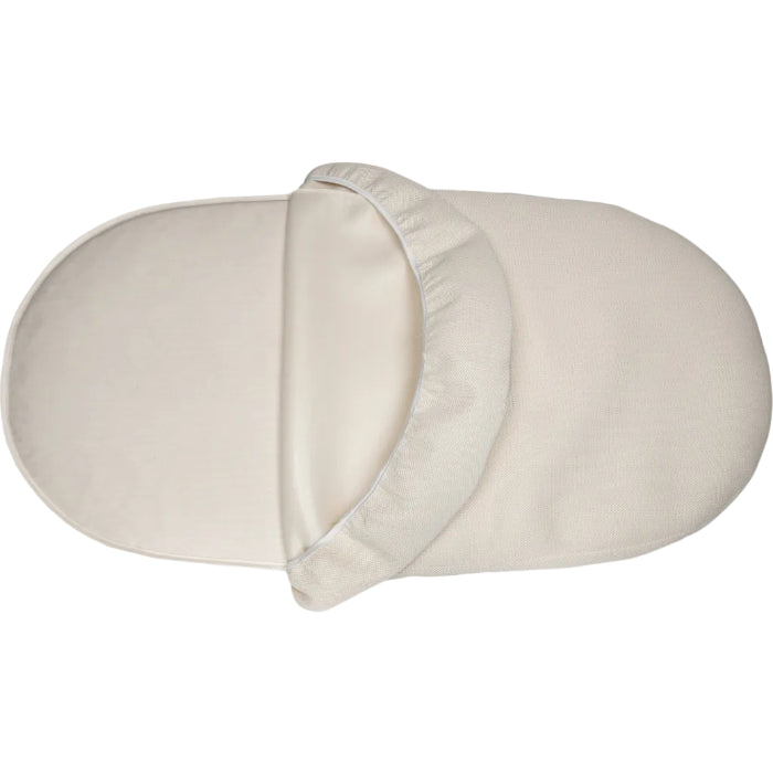 oval crib mattress with a fitted sheet on a white background