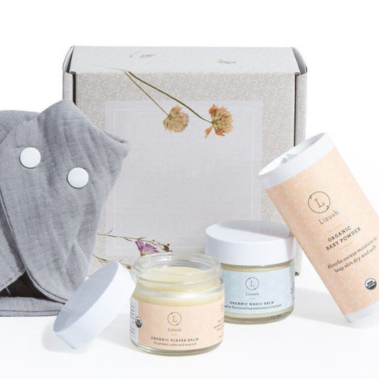 Set of skincare products including a gray towel, jars, and a tube on a white background