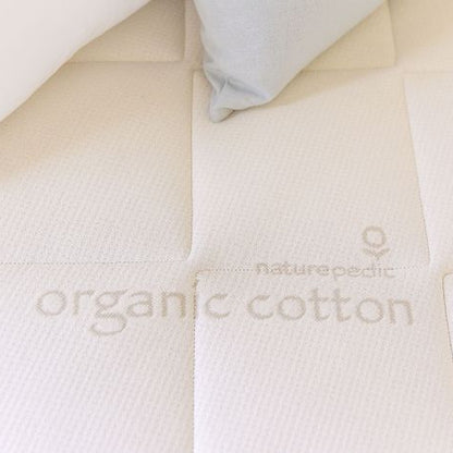 Close-up of an organic cotton mattress 'Naturepedic' branding.