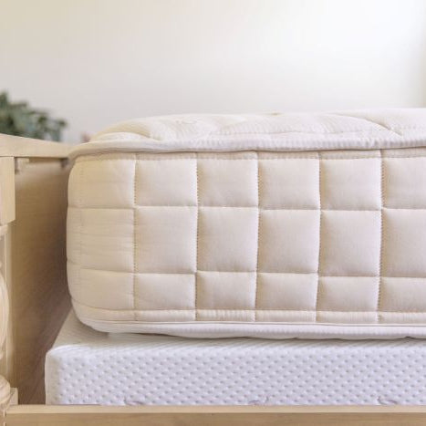 Mattress on a wooden bed frame with a blurred background