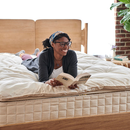Person reading a book on a Wooly 3" Organic Wool Mattress Topper on a bed