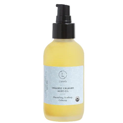 Yellow bottle of organic calming baby oil with a black pump on a light gray background.