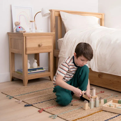 Child playing with wooden blocks in a bedroom with savona nightstand 